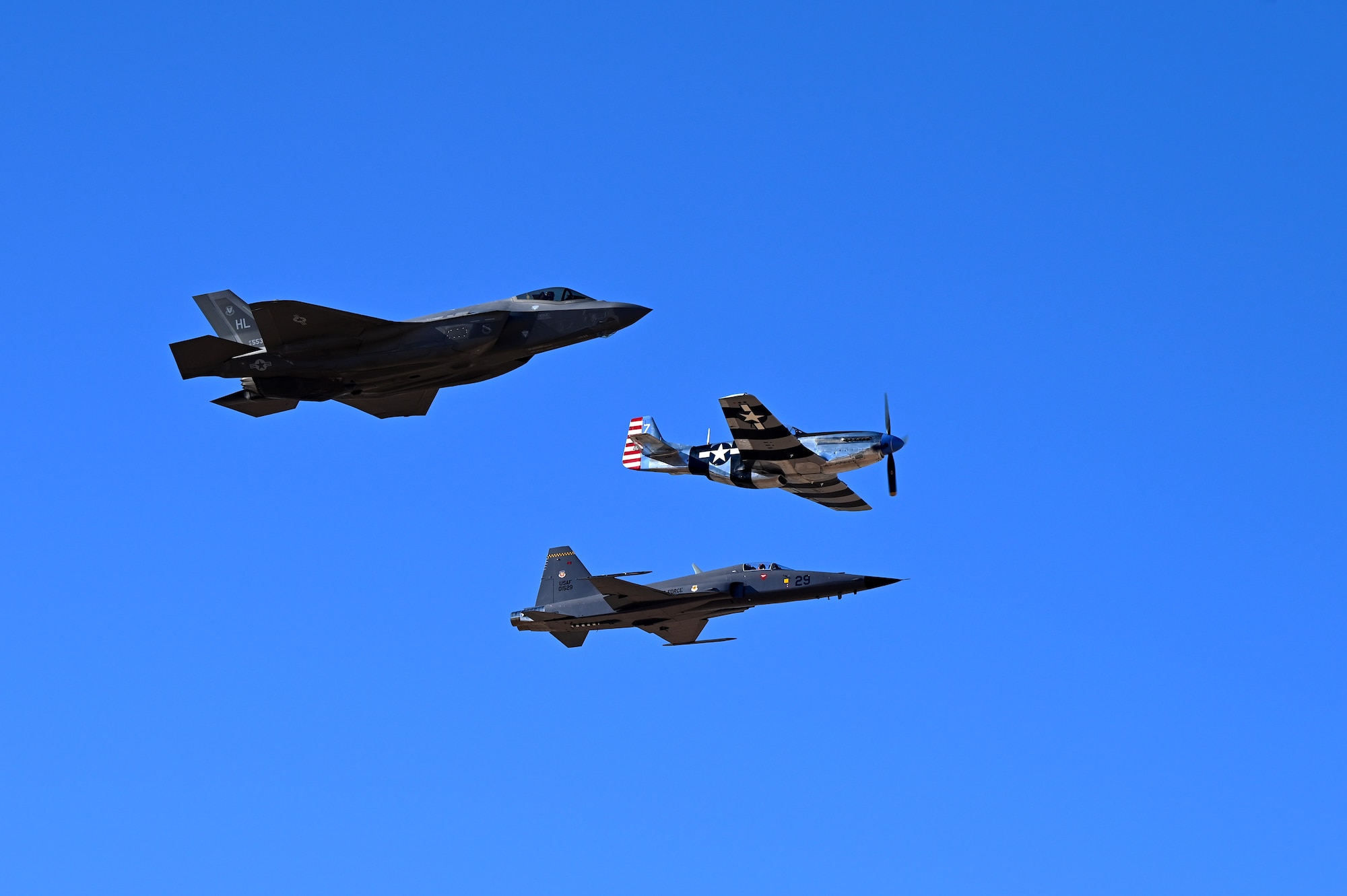 A U.S. Air Force F-35A Lightning II, P-51 Mustang and U.S. Air Force F-5 Tiger aircraft fly in formation during Heritage Flight Training Course at Davis-Monthan Air Force Base, Arizona, March 1, 2025. Heritage flights are flown with past and current U.S. Air Force aircraft to honor the past, present and future of American airpower. (U.S. Air Force photo by Senior Airman Andrew Garavito)