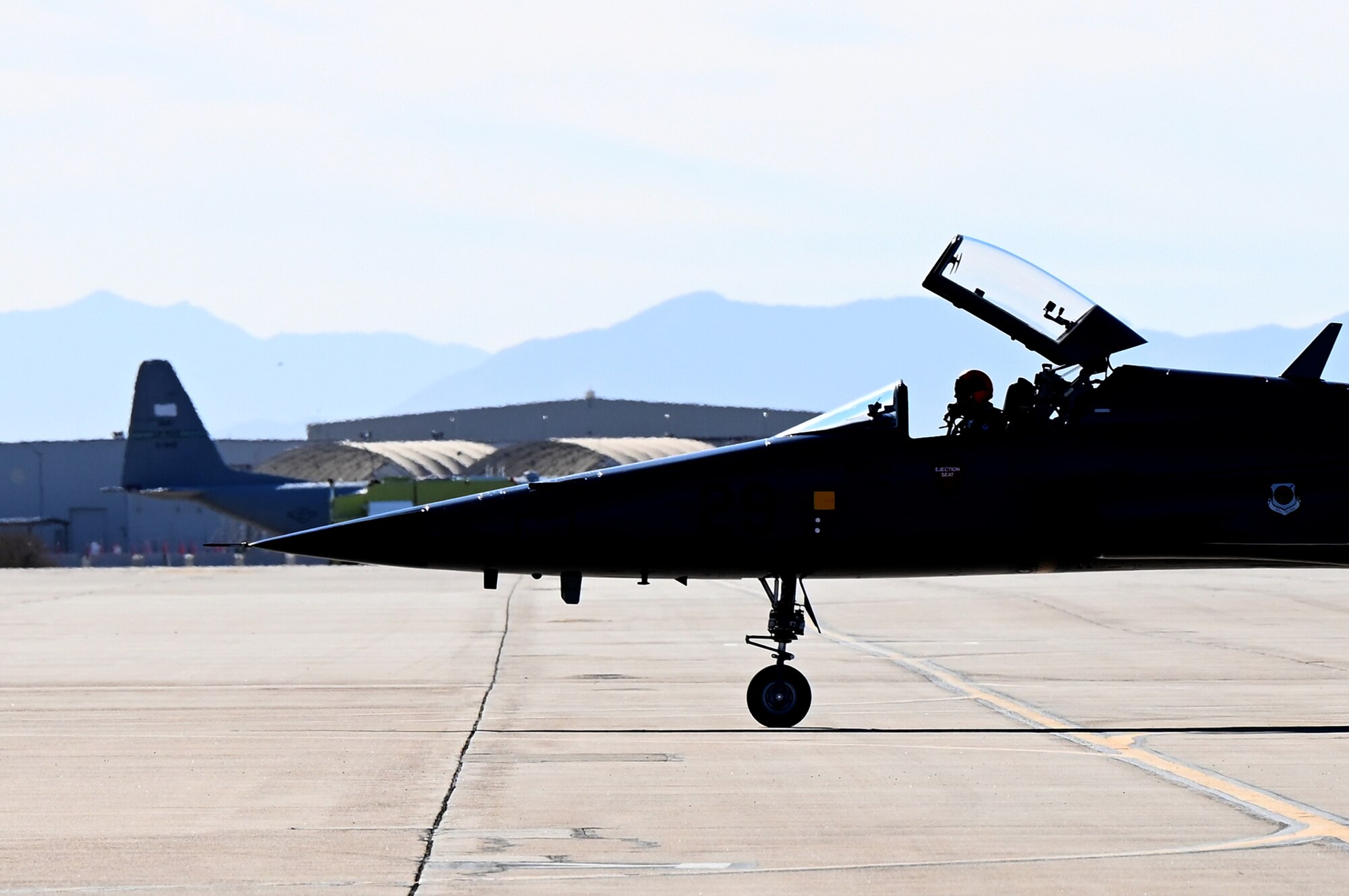 A U.S. Air Force F-5 Tiger aircraft raises its canopy before taxing back to formation on the flightline during Heritage Flight Training Course at Davis-Monthan Air Force Base, Arizona, March 1, 2025. The Air Force Heritage Flight team consists of civilian pilots qualified to fly vintage warbirds in formation with modern Air Force single-ship demonstration teams. (U.S. Air Force photo by Senior Airman Andrew Garavito)