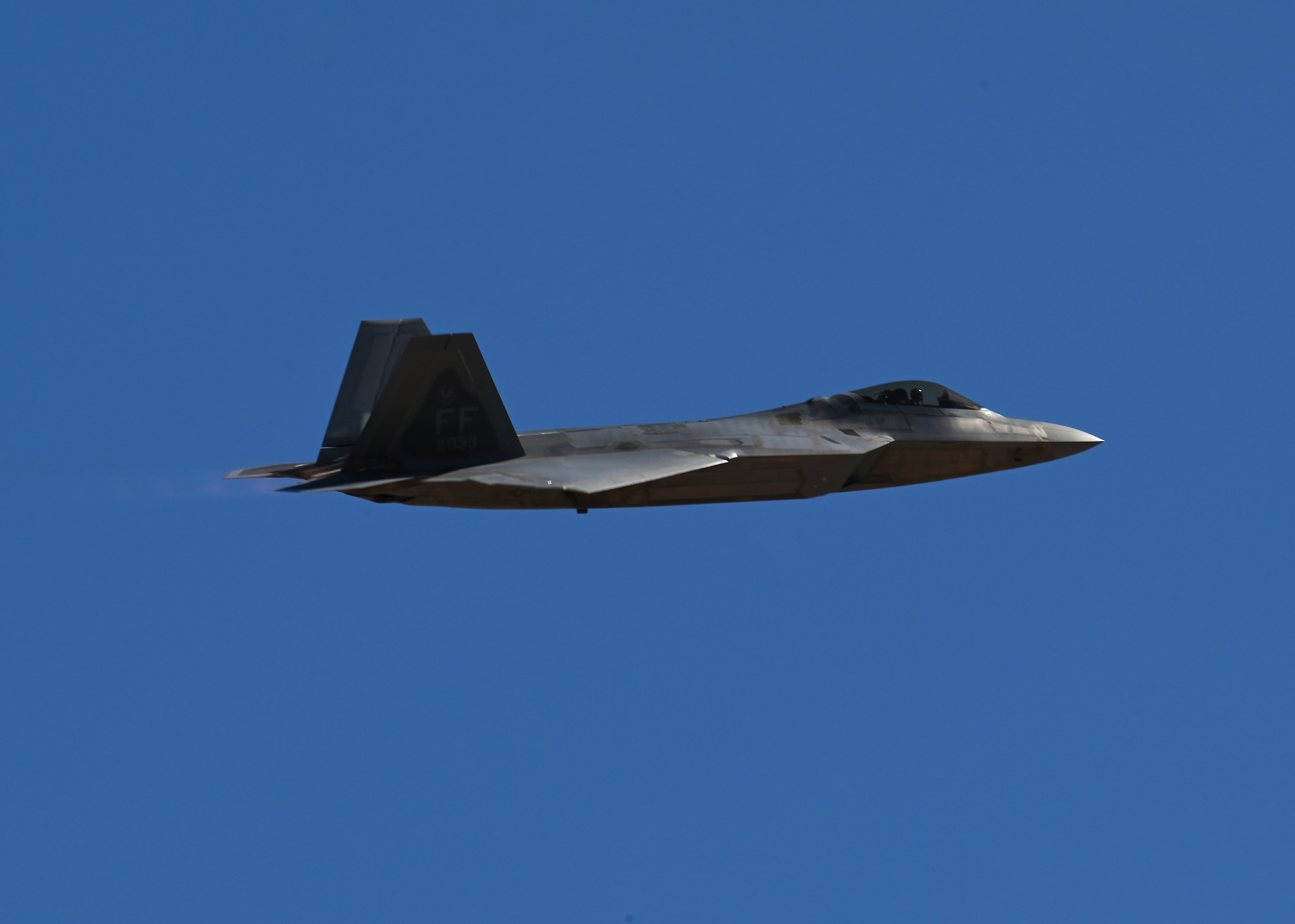 A U.S. Air Force F-22 Raptor aircraft speeds by during the Heritage Flight Training Course at Davis-Monthan Air Force Base, Arizona, March 2, 2025. The HFTC showcases Air Power and military capabilities while certifying Air Combat Command Demonstration Teams for the 2025 airshow season. (U.S. Air Force photo by Staff Sgt. Abbey Rieves)