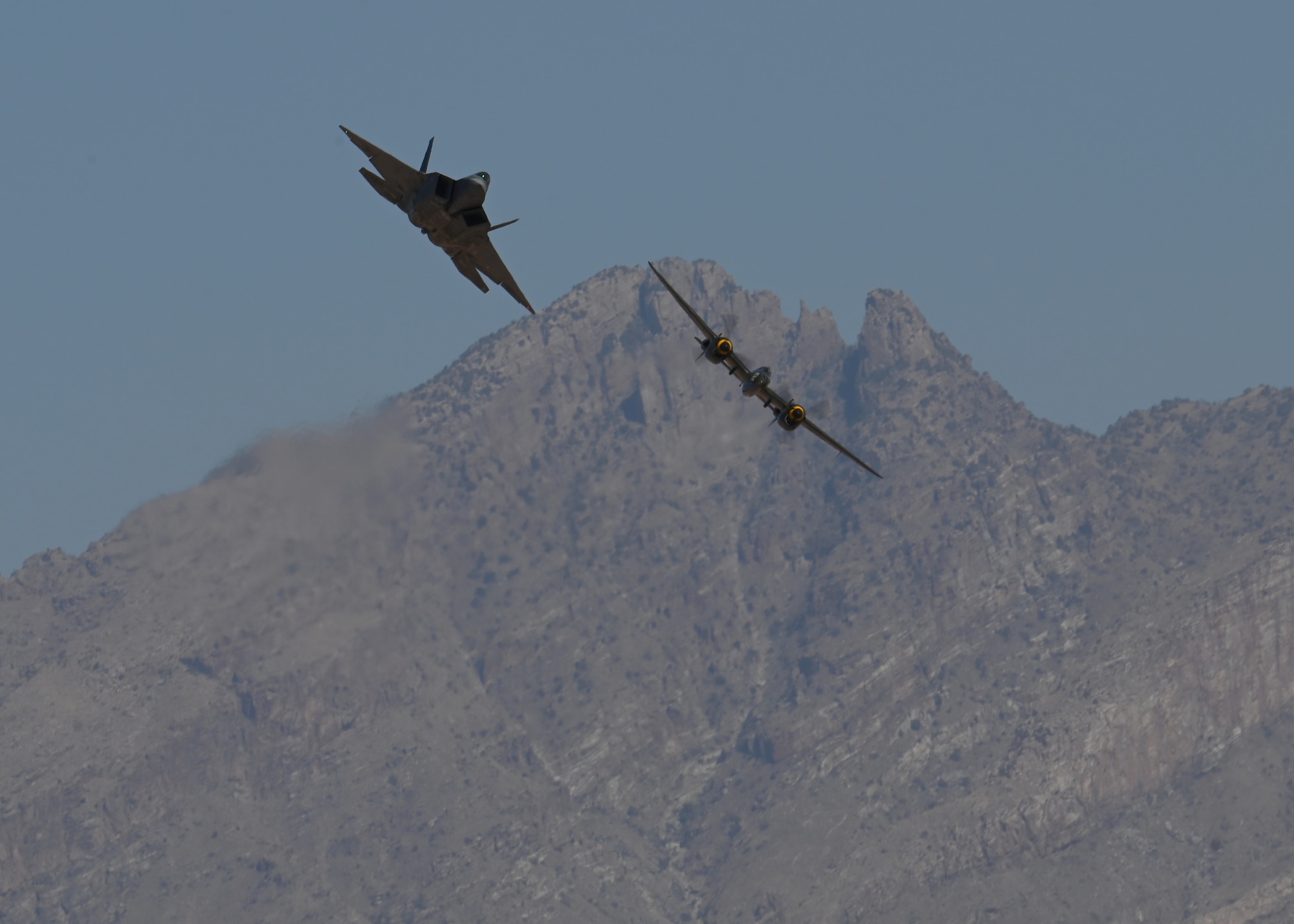 A U.S. Air Force F-22 Raptor aircraft, left, and the P-38 Lightning aircraft, right, fly during the Heritage Flight Training Course at Davis-Monthan Air Force Base, Arizona, March 2, 2025. The HFTC raises awareness of the Air Force mission and serves as a living memorial to the men and women who have served or are currently serving in the Air Force. (U.S. Air Force photo by Staff Sgt. Abbey Rieves)