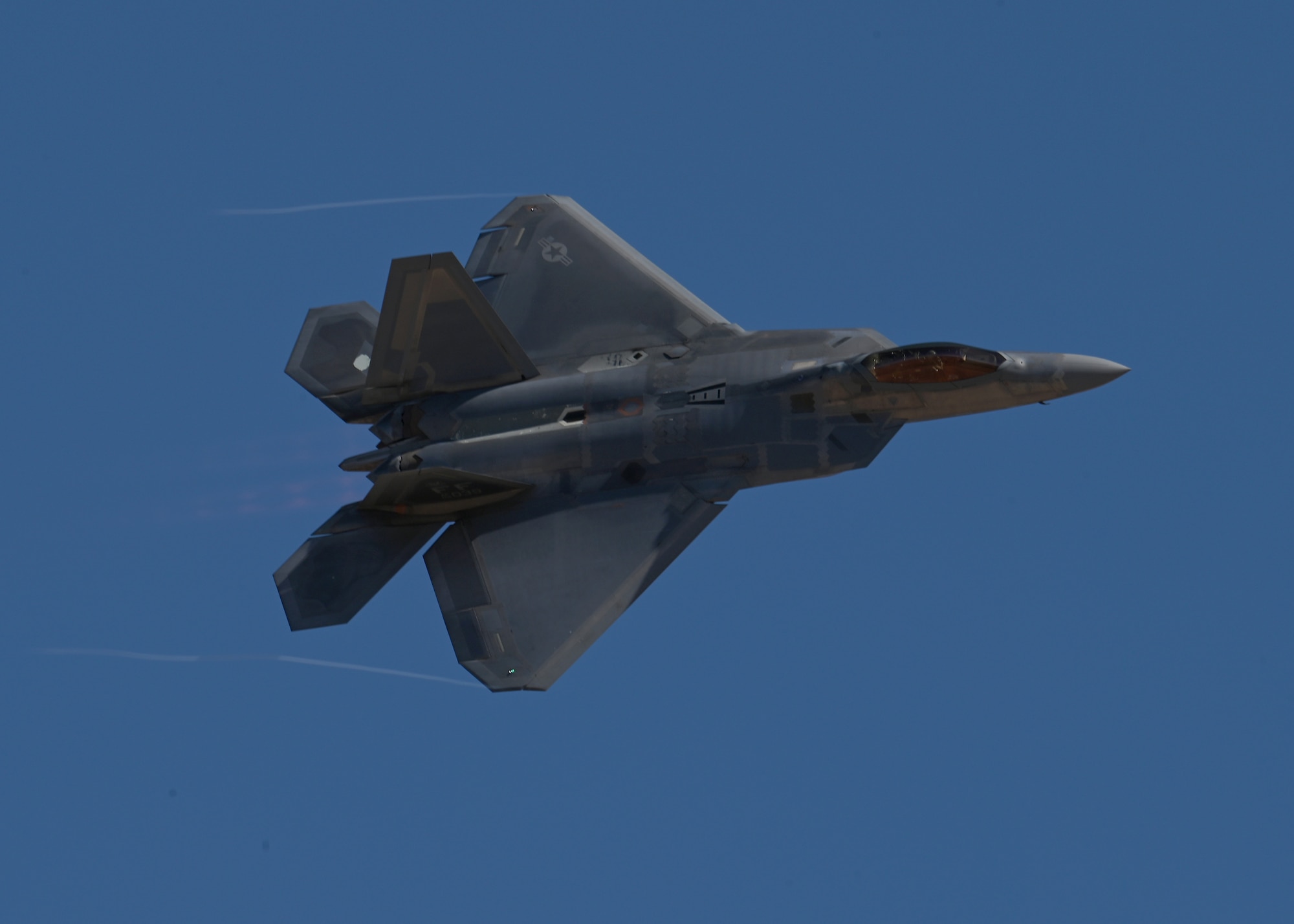A U.S. Air Force F-22 Raptor aircraft demonstrates aerial capabilities during the Heritage Flight Training Course at Davis-Monthan Air Force Base, Arizona, March 2, 2025. The Air Combat Command F-22 Raptor Demonstration Team performs precision aerial maneuvers to demonstrate the unique capabilities of the fifth-generation fighter aircraft. (U.S. Air Force photo by Staff Sgt. Abbey Rieves)