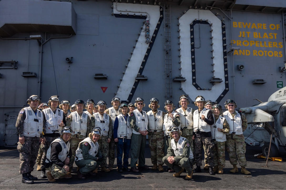 250301-N-TD381-2271 AT SEA (March 1, 2025) Distinguished visitors from U.S. Forces Korea, Commander, U.S. Naval Forces Korea, and the Republic of Korea Navy join together with leadership from the Nimitz-class aircraft carrier USS Carl Vinson (CVN 70), Carrier Air Wing 2, and Carrier Strike Group 1 on Vinson’s flight deck, March 1, 2025. Vinson, the flagship of Carrier Strike Group ONE, is underway conducting routine operations in the U.S. 7th Fleet area of operations. (U.S. Navy photo by Mass Communication Specialist 2nd Class Isaiah B. Goessl)