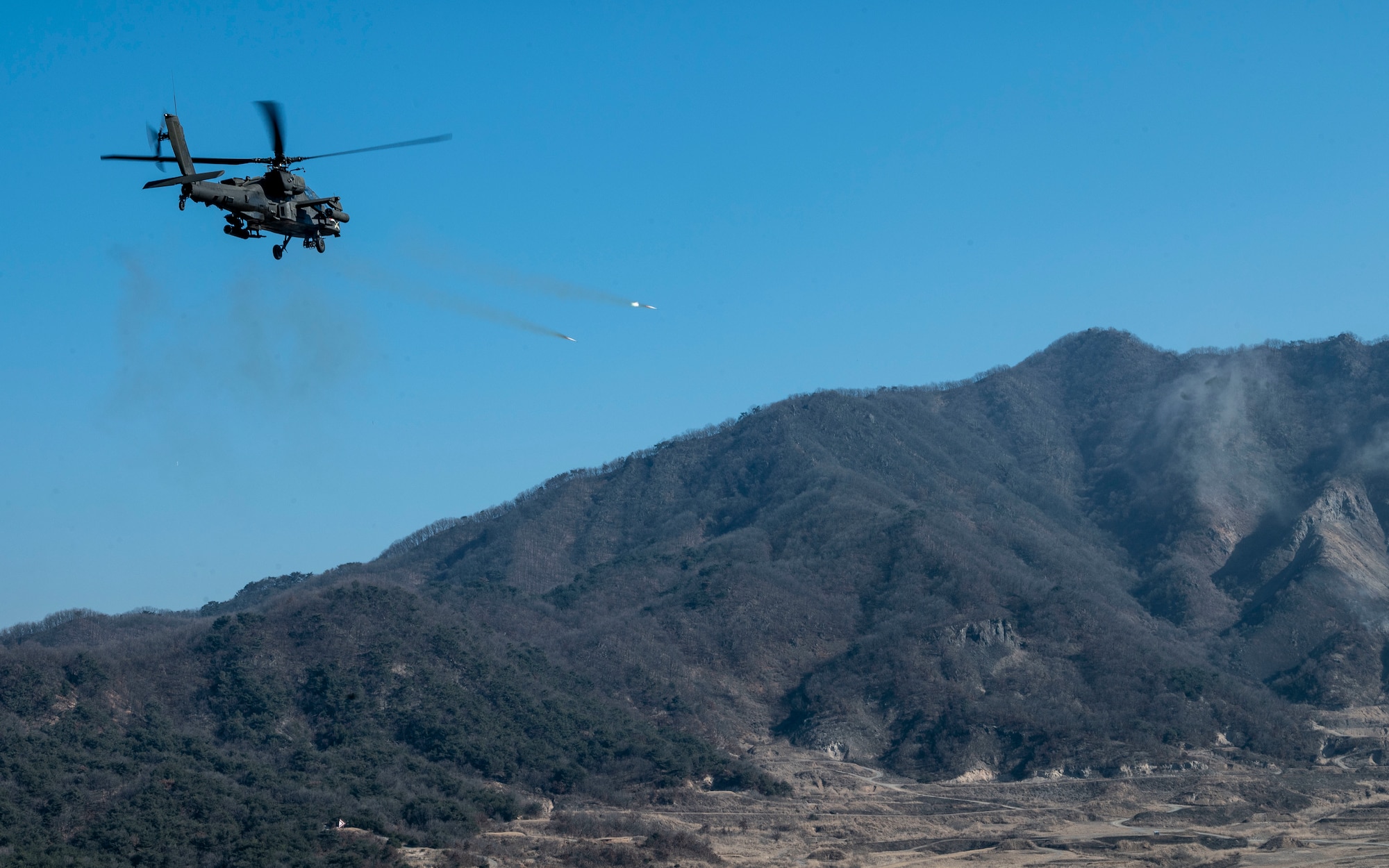 A U.S. Army AH-64 Apache assigned to the 5-17 Air Cavalry Squadron fires two 2.75-inch rockets toward targets at Rodriguez Live Fire Complex, Republic of Korea, Feb. 24, 2025. U.S. Army, U.S. Air Force, and ROK Army assets participated in a combined arms live fire exercise which demonstrates the U.S.’s ironclad resolve to the U.S.-ROK alliance and strengthens collective deterrence on the Korean Peninsula. (U.S. Air Force photo by Staff Sgt. Ashley N. Mikaio)