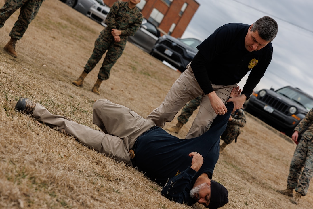 Paul Notarfrancesco, top, and Michael Rivera, bottom, law enforcement training officers with the Provost Marshal’s Office, demonstrate defensive tactics during Security Augmentation Force training on Marine Corps Base Quantico, Virginia, Feb. 25, 2025. SAF provides Marines from other occupational specialties an opportunity to increase readiness and fulfill an additional billet which military police can utilize in case of emergencies. (U.S. Marine Corps photo by Lance Cpl. Braydon Rogers)