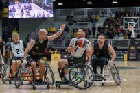 Carlos Valerio, center left, plays defense during a wheelchair basketball match vs. New Zealand at the 2025 Invictus Games, held Feb. 8-16 in Vancouver and Whistler, Canada. As a member of Team U.S. for the second time, Valerio – a Navy veteran, Army civilian employee and gastric cancer survivor – competed in the biathlon and on a mixed-nation “Unconquered” team in basketball, earning a bronze medal. It was the first time an Unconquered team earned a medal at Invictus.