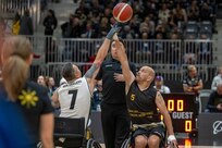 Carlos Valerio, right, vies for control of the ball during a wheelchair basketball match at the 2025 Invictus Games, held Feb. 8-16 in Vancouver and Whistler, Canada. As a member of Team U.S. for the second time, Valerio – a Navy veteran, Army civilian employee and gastric cancer survivor – competed in the biathlon and on a mixed-nation “Unconquered” team in basketball, earning a bronze medal. It was the first time an Unconquered team earned a medal at Invictus.