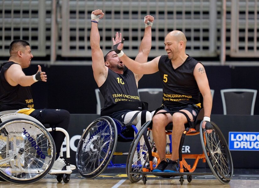 Carlos Valerio, right, high-fives a teammate during a wheelchair basketball match at the 2025 Invictus Games, held Feb. 8-16 in Vancouver and Whistler, Canada. As a member of Team U.S. for the second time, Valerio – a Navy veteran, Army civilian employee and gastric cancer survivor – competed in the biathlon and on a mixed-nation “Unconquered” team in basketball, earning a bronze medal. It was the first time an Unconquered team earned a medal at Invictus.