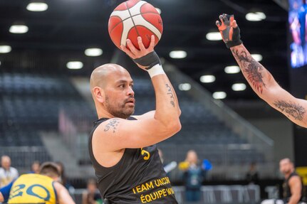 Carlos Valerio, a gastric cancer survivor, Navy veteran and current Army civilian at U.S. Army Medical Logistics Command, looks to shoot during a wheelchair basketball match during the 2025 Invictus Games, held Feb. 8-16 in Vancouver and Whistler, Canada. Valerio, a member of Team U.S., competed as part of a mixed-nation "Unconquered" team, winning a bronze medal in wheelchair basketball. It was the first time an Unconquered team has medaled in the event's 11-year history.