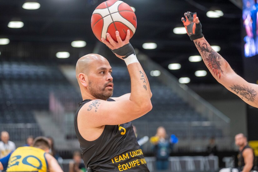 Carlos Valerio, a gastric cancer survivor, Navy veteran and current Army civilian at U.S. Army Medical Logistics Command, looks to shoot during a wheelchair basketball match during the 2025 Invictus Games, held Feb. 8-16 in Vancouver and Whistler, Canada. Valerio, a member of Team U.S., competed as part of a mixed-nation "Unconquered" team, winning a bronze medal in wheelchair basketball. It was the first time an Unconquered team has medaled in the event's 11-year history.