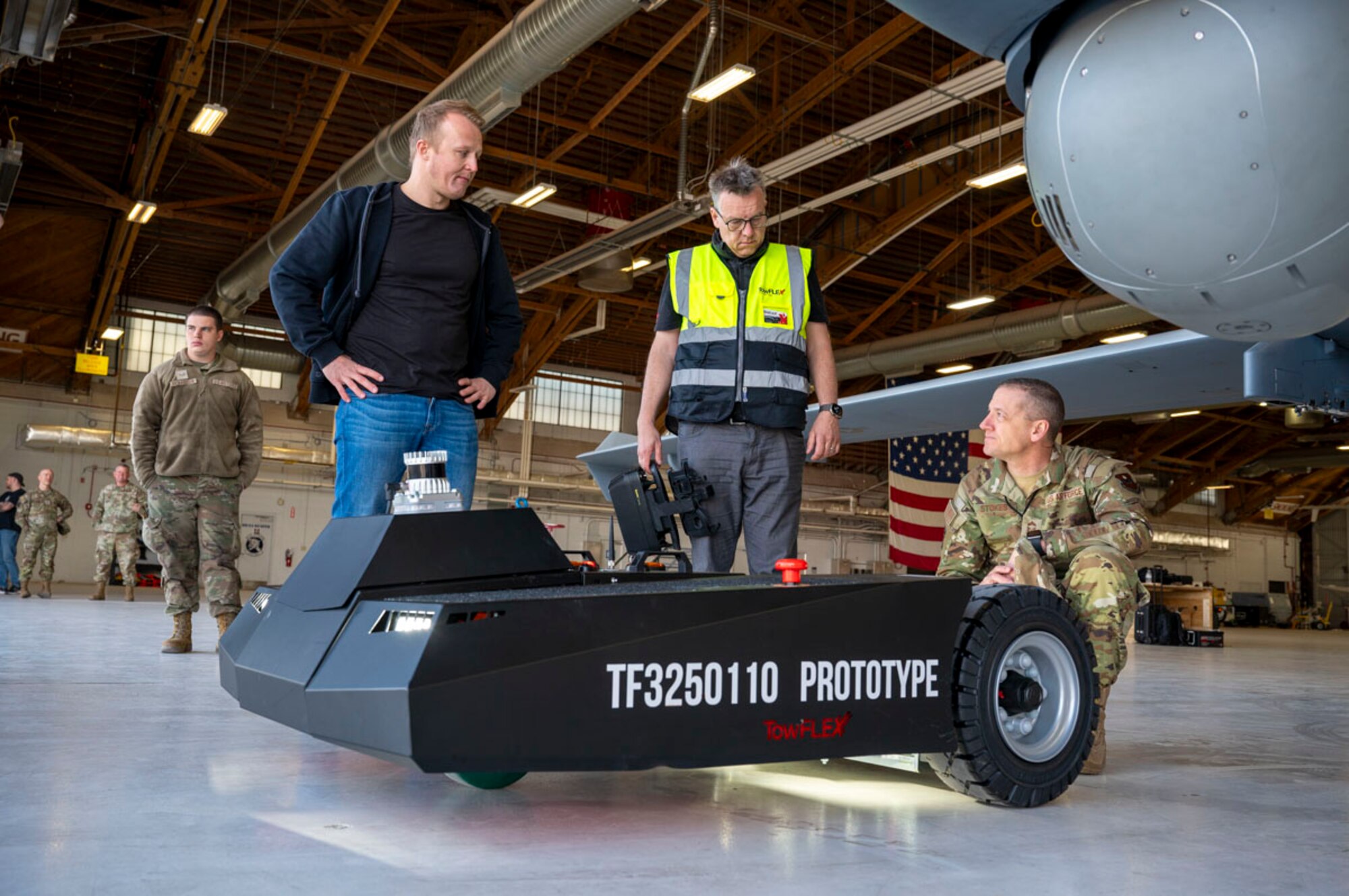 Tobias Strobl, TowFLEXX Miltech chief executive officer, left, and Alex Shickling,TowFLEXX president, middle, conducts a prototype demonstration for U.S. Air Force Chief Master Sgt. Andrew Stokes, 49th Maintenance Group senior enlisted leader, at Holloman Air Force Base, New Mexico, Feb. 27, 2025. (U.S. Air Force photo by Senior Airman Isaiah Pedrazzini)