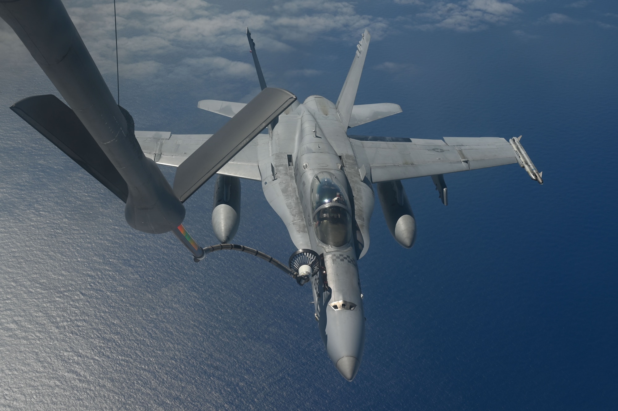 A U.S. Air Force KC-135 Stratotanker aircraft assigned to the 506th Expeditionary Air Refueling Squadron fuels a U.S. Marine Corps F/A-18C Hornet assigned to Marine Fighter Attack Squadron 312, Marine Corps Air Station, Iwakuni, Japan, during a training mission over the Pacific Ocean, Feb. 26, 2025. The 506 EARS crew led the refueling mission with the Marine Corps out of Andersen Air Force Base, Guam. (U.S. Air Force photo by Airman 1st Class Natasha Ninete)