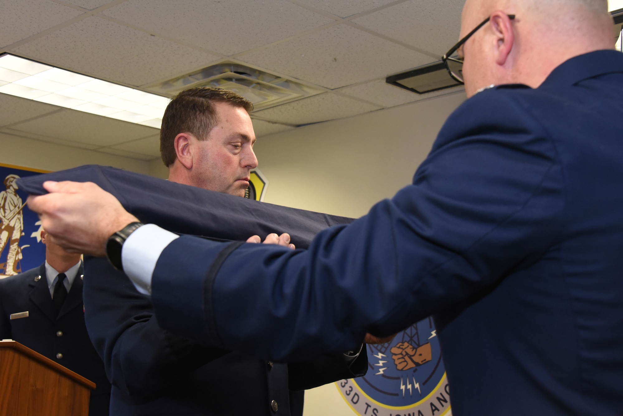 Brig. Gen. Mark A. Muckey, Deputy Adjutant General for the Iowa Air National Guard, left, sheathes the flag of the 133rd Test Squadron