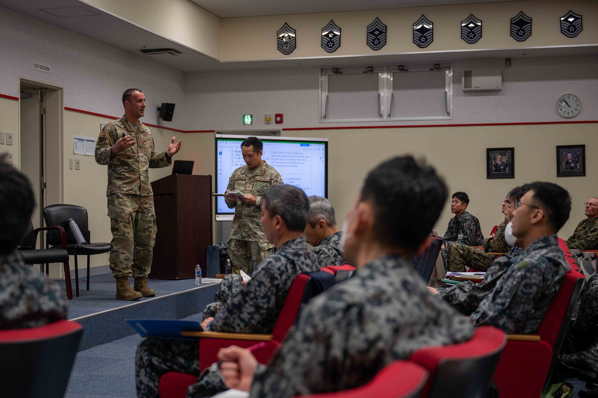 U.S. Air Force Chief Master Sgt. Brandon Wolfgang, 18th Wing command chief, briefs the 18th Wing’s mission during a bilateral senior enlisted leadership training at Kadena Air Base, Japan, Feb. 18, 2025.