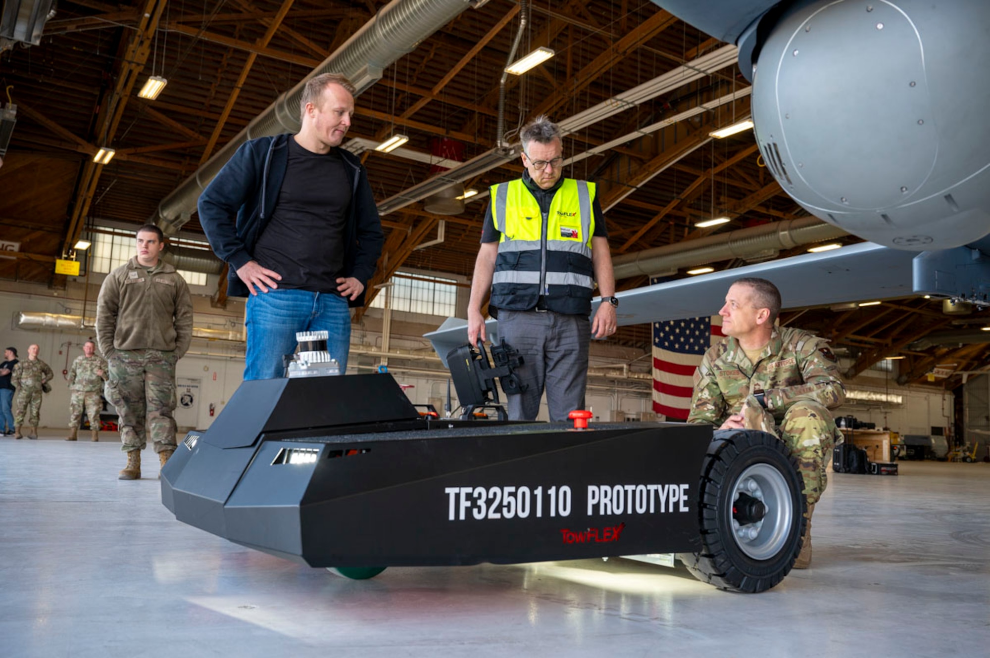 Tobias Strobl, TowFLEXX Miltech chief executive officer, left, and Alex Shickling,TowFLEXX president, middle, conducts a prototype demonstration for U.S. Air Force Chief Master Sgt. Andrew Stokes, 49th Maintenance Group senior enlisted leader, at Holloman Air Force Base, New Mexico, Feb. 27, 2025. (U.S. Air Force photo by Senior Airman Isaiah Pedrazzini)