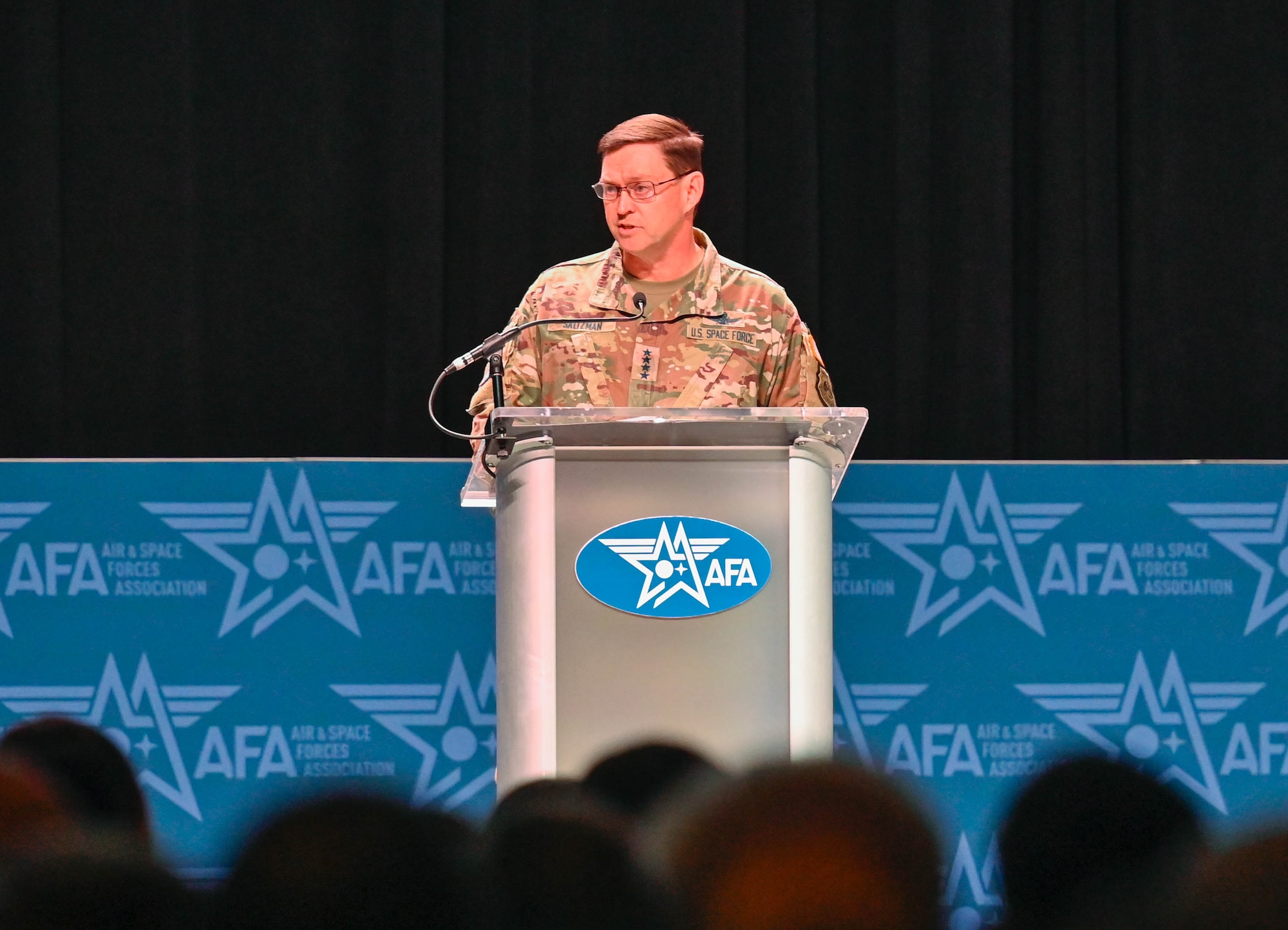 A military leader speaks at a podium.