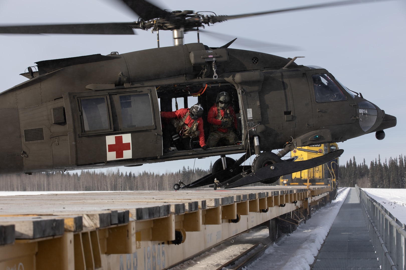 An Alaska Army National Guard HH-60M Black Hawk helicopter assigned to Golf Company, 2-211th General Support Aviation Battalion, lands on an Alaska Railroad train car while supporting Special Operations Forces Arctic Medic 2025 near Fairbanks, Alaska, Feb. 20, 2025. SOFAM 2025 is a Special Operations Command North training and validation event for unit medics that conduct exercises and operations in the North American Arctic.