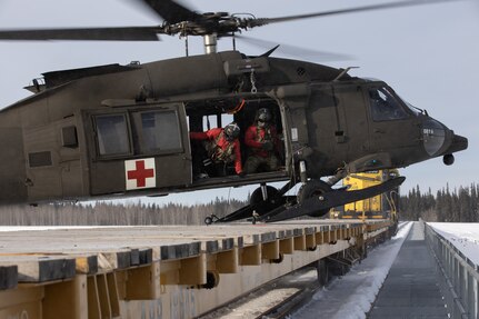 An Alaska Army National Guard HH-60M Black Hawk helicopter assigned to Golf Company, 2-211th General Support Aviation Battalion, lands on an Alaska Railroad train car while supporting Special Operations Forces Arctic Medic 2025 near Fairbanks, Alaska, Feb. 20, 2025. SOFAM 2025 is a Special Operations Command North training and validation event for unit medics that conduct exercises and operations in the North American Arctic.