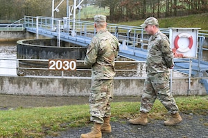 U.S. Air Force Staff Sgt. Ruben Carrasco, 52nd Civil Engineer Squadron water and fuel systems maintenance specialist, explains the process of wastewater treatment to Col. Kevin Crofton, 52nd Fighter Wing commander, during a tour of the wastewater treatment facility at Spangdahlem Air Base, Germany, Feb. 28, 2025. The facility uses nanobubble technology to help break down surfactants like detergents and shampoos, as well as aircraft de-icing chemicals. (U.S. Air Force photo by Senior Airman Darius Frazier)