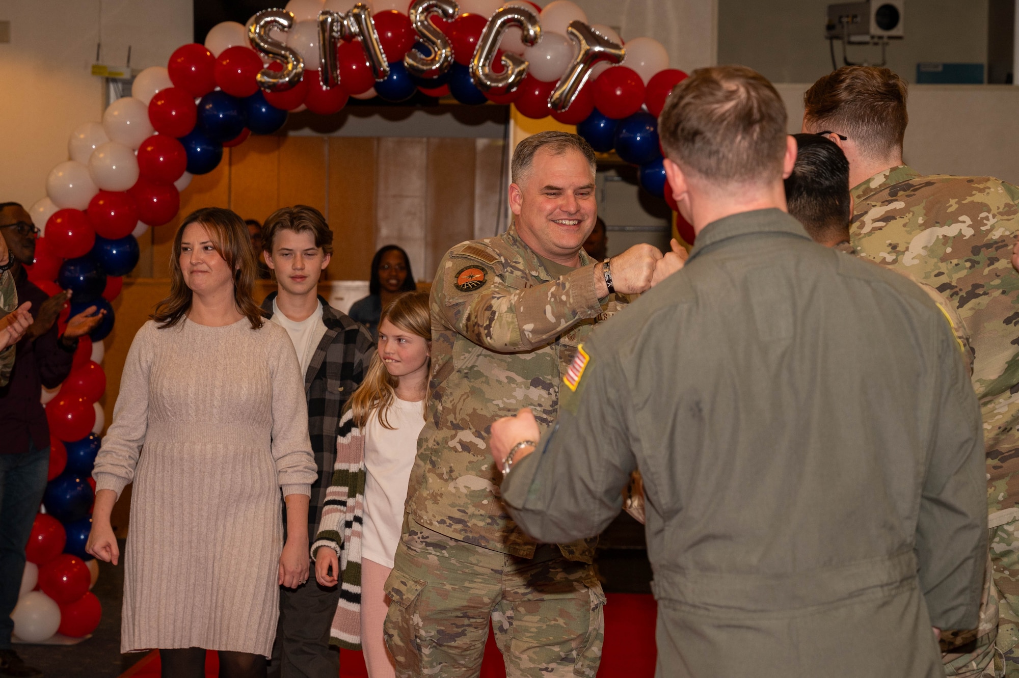 A service member and family walk down runway.