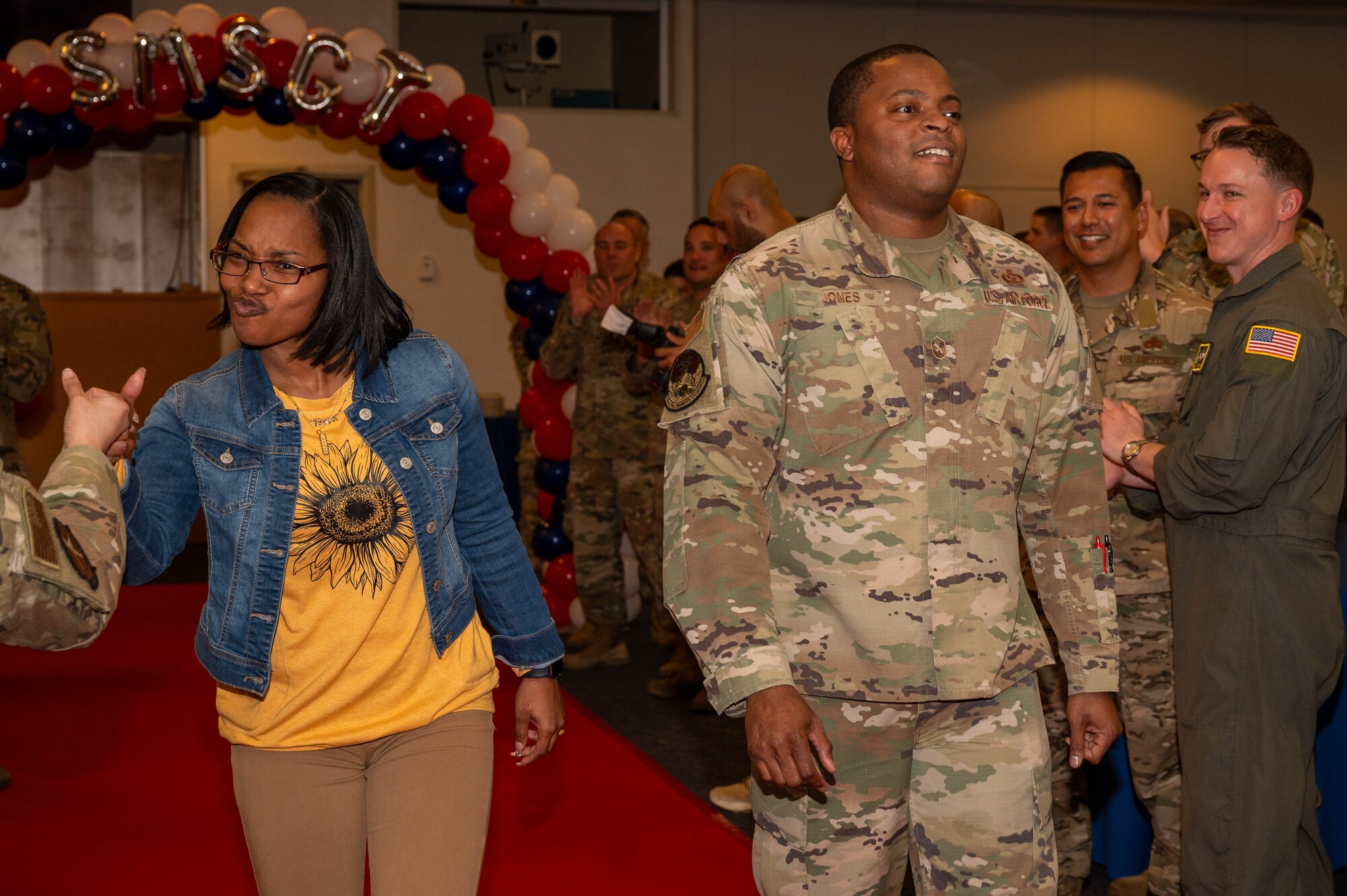 A service member and spouse walk down runway.