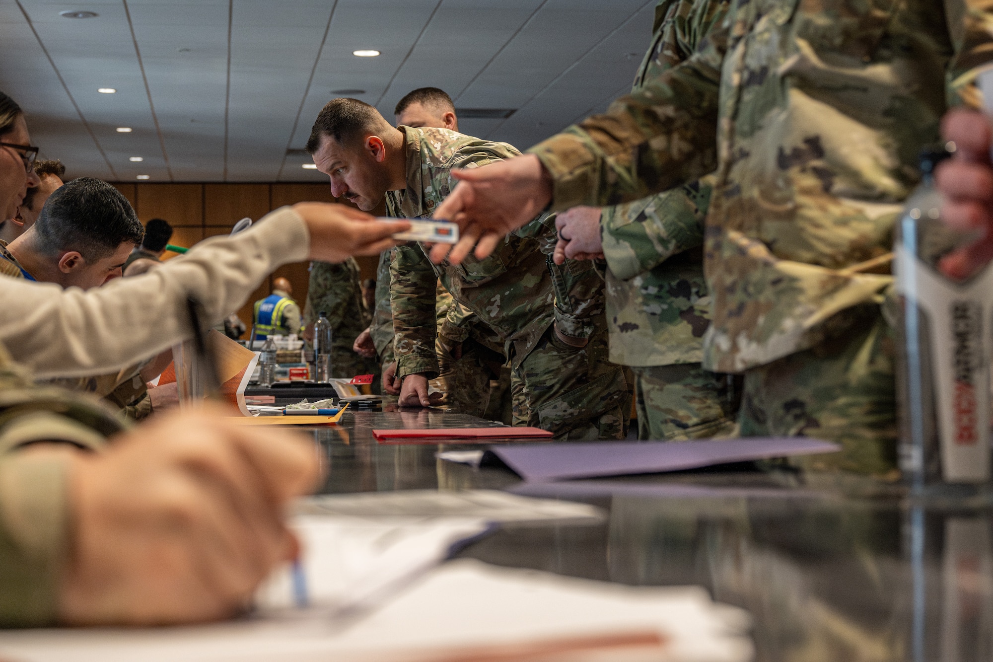A person hands another person a CAC card.