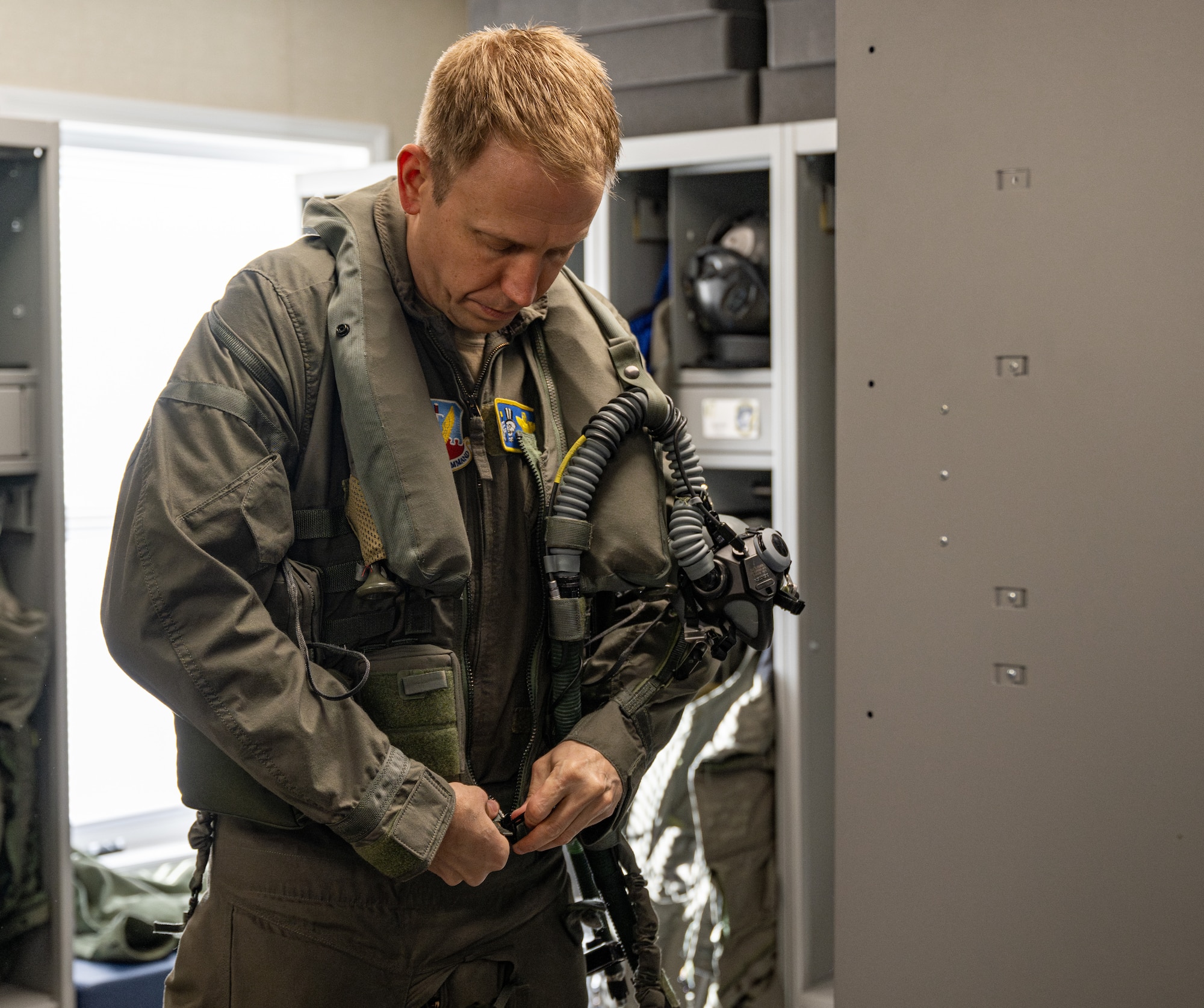 A pilot zips up his suit.