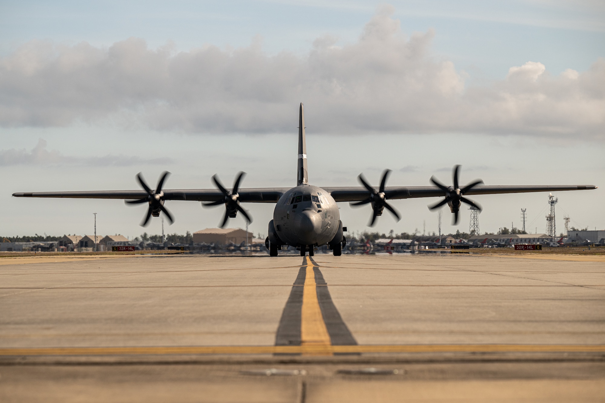 A photo of a C-130 is taxing on the flightline.