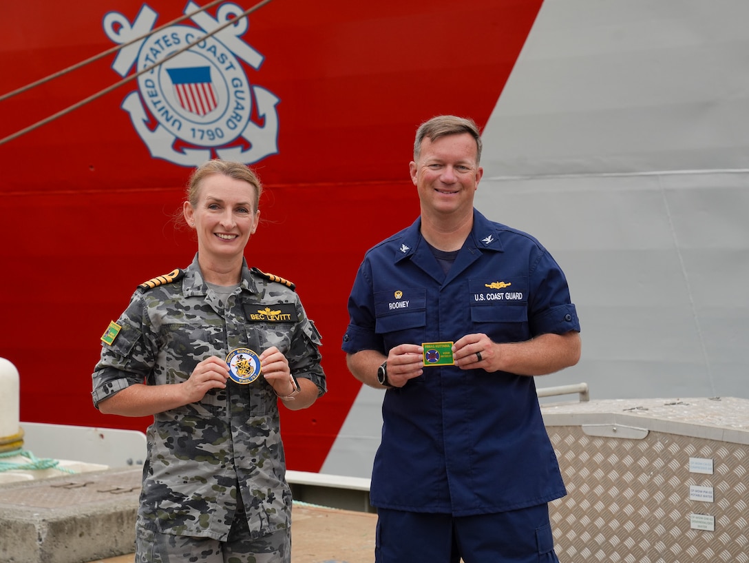 Coast Guard Capt. Matthew Rooney, the commanding officer of the Coast Guard Cutter Midgett (WMSL 757) and Royal Australian Navy Capt. Rebecca Levitt, the commanding officer of His Majesty’s Australian Ship Kuttabul, exchange patches during a media engagement in Sydney, Feb. 25, 2025. In the spirit of Pacific Quadrilateral Defense Coordinating Group, the Coast Guard continues its vital collaboration with Australian law enforcement to identify maritime vulnerabilities and cooperate on solutions to reduce risk to safety, health, and security throughout Oceania. (U.S. Coast Guard photo by Petty Officer 3rd Class Jennifer Nilson)