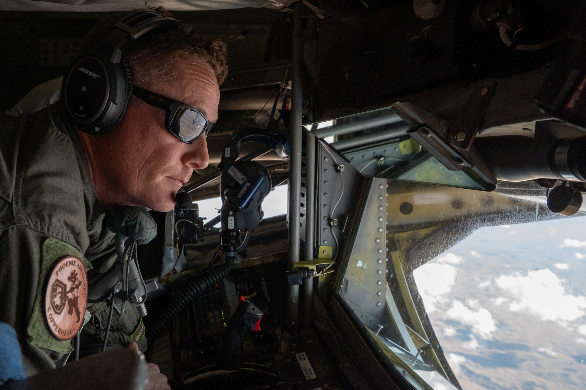 Master Sgt. Nick Savasta, a boom operator with the Arizona Air National Guard 161st Air Refueling Wing, focuses intently as he prepares to guide the KC-135's refueling boom toward an approaching aircraft at Goldwater Air National Guard Base, Ariz., Nov. 8, 2024. The Honorary Commanders Program allows civic leaders to observe firsthand the precision required in this mission-critical task. (U.S. Air Force photo by Senior Airman Alexis Orozco)
