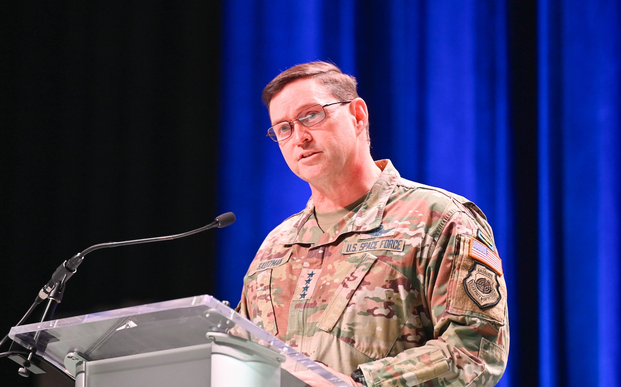 A military member speaks at a podium.