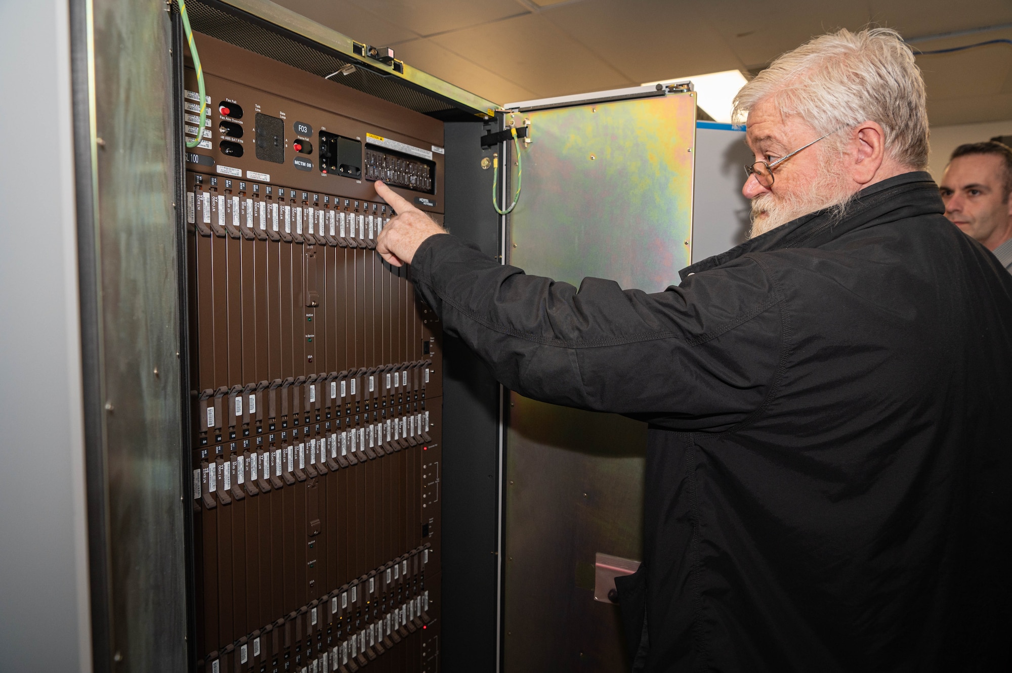 Charles Kruckman, U.S. Strategic Command communications contractor, looks over one of the panels to the Meridian Stored Logic 100 telephone switch Feb. 26, 2025. Kruckman worked on the telephone switch when he was a young Airman with the 55th Communications Squadron. (U.S. Air Force photo by Daniel Martinez)
