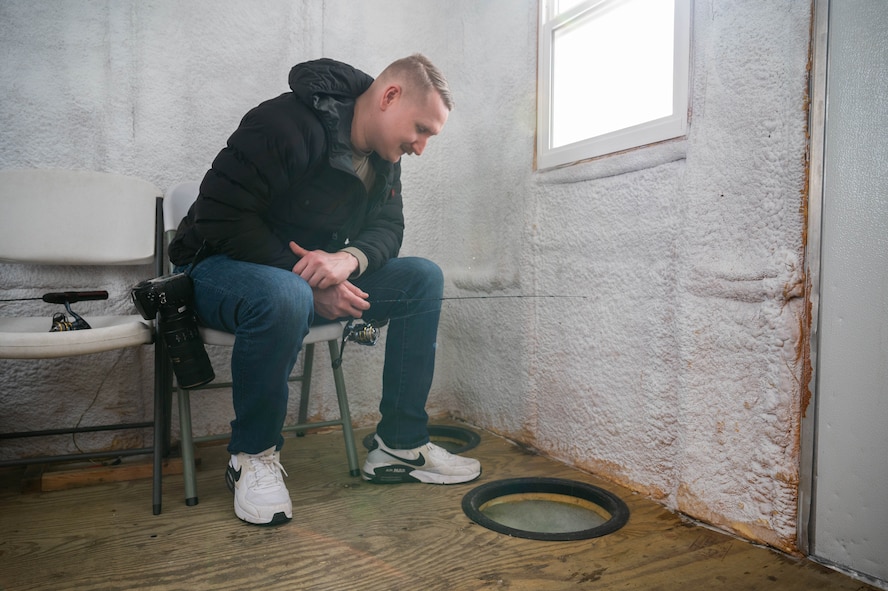 Senior Airman Kyle Wilson, 5th Bomb Wing public affairs specialist, ice fishes on Devils Lake, North Dakota, Feb. 25, 2025. Wilson is an experienced fisherman, but this was his first time ice fishing. (U.S. Air Force photo by Senior Airman Kendra A. Ransum)