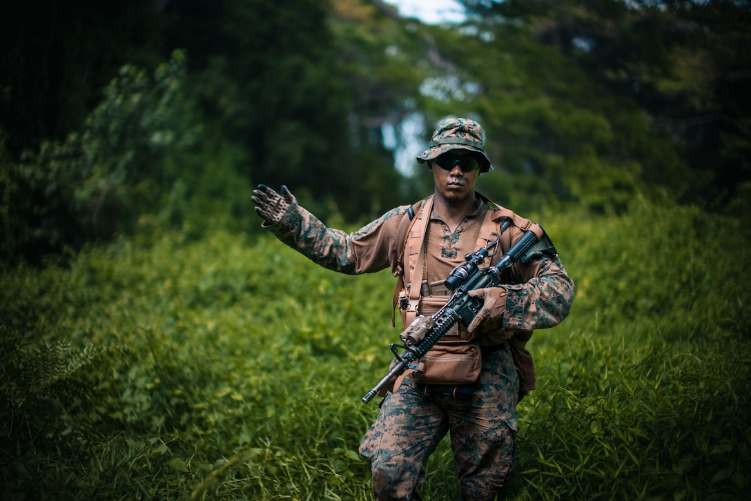 A U.S. Marine with the 1st Light Armored Reconnaissance Battalion, attached to Marine Rotational Force-Southeast Asia, relays a hand and arm signal while conducting a patrol in Sattahip, Thailand, Feb. 26, 2025, during Exercise Cobra Gold 2025. Cobra Gold is the largest joint and combined exercise in mainland Asia, held annually in Thailand, showcasing the U.S. commitment to the region by building interoperability, multilateral cooperative arrangements, and advancing common interests through our commitment to allies and partners in ensuring a free and open Indo-Pacific. MRF-SEA is a rotational unit derived from elements of I MEF executing a U.S. Marine Corps Forces, Pacific operational model that involves training events and exchanges with partner military subject matter experts, promotes security goals with allied and partner nations, and ensures a persistent I MEF stand-in presence west of the International Date Line. (U.S. Marine Corps photo by Sgt. Christian Tofteroo)