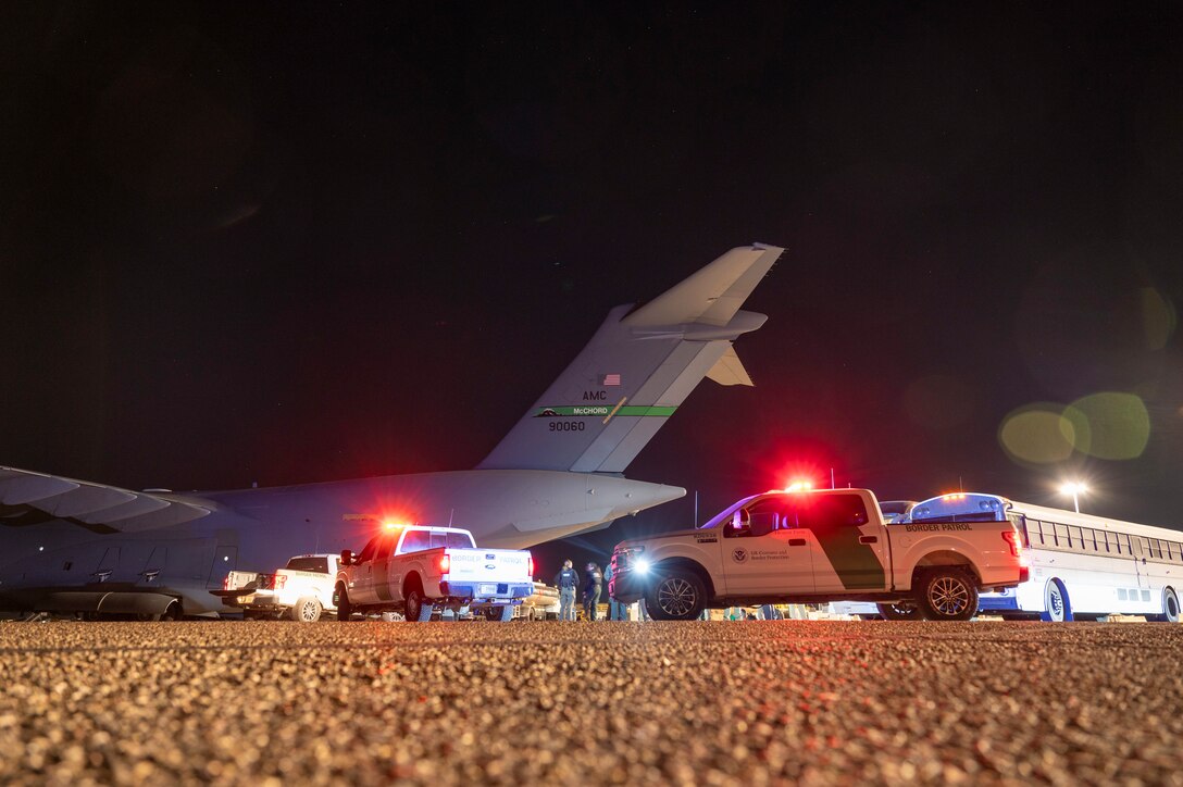 U.S. Airmen and U.S. Customs and Border Protection Agency personnel prepare to load illegal aliens onto a C-17 Globemaster III at Tucson International Airport in Tucson, Ariz., Jan. 23, 2025. Under the direction of U.S. Northern Command, U.S. Transportation Command is supporting Immigration and Customs Enforcement removal flights by providing military airlift.