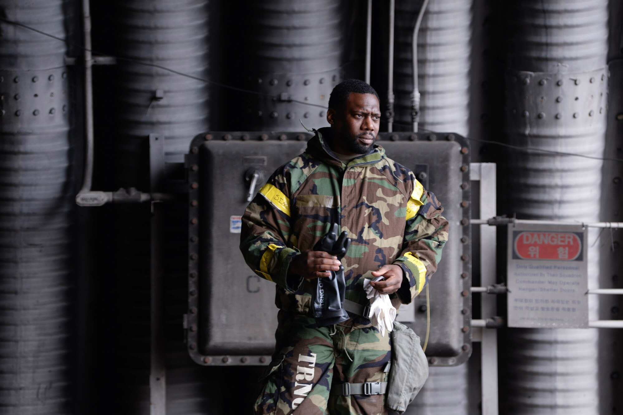 U.S. Air Force Staff Sgt. O’Brine Brewster, 51st Maintenance Group quality assurance inspector, dons mission oriented protective posture gear ahead of a rapid aircraft and personnel decontamination training at Osan Air Base, Republic of Korea, Feb. 28, 2025. In the event of a chemical, biological, radiological, or nuclear attack, properly donned gear can protect wearers from physical harm. (U.S. Air Force photo by Staff Sgt. Kahdija Slaughter)