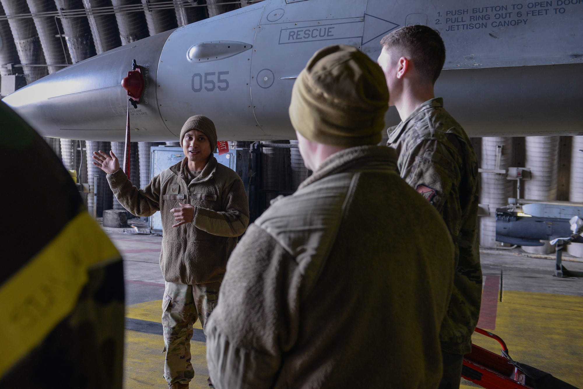 U.S. Air Force Tech. Sgt. Gerald Cruz, 36th Fighter Generation Squadron specialist flight Airman, answers questions about how to rapidly decontaminate an F-16 Fighting Falcon assigned to the 36th Fighter Squadron at Osan Air Base, Republic of Korea, Feb. 28, 2025. The instructional and hands-on training allowed several Airmen assigned to the 51st Maintenance Group to hone their contingency response capabilities by decreasing the time it takes to decontaminate personnel and aircraft at a moment’s notice. (U.S. Air Force photo by Staff Sgt. Kahdija Slaughter)