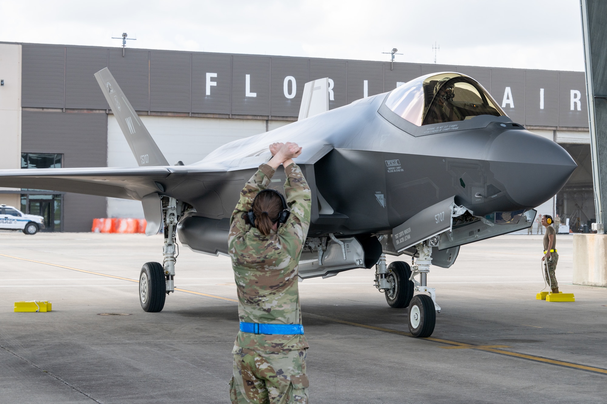 An aircraft maintainer marshals in a F-35A Lightning II aircraft during its arrival.