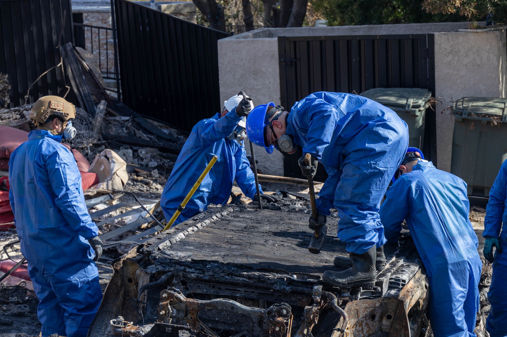 Tech. Sgt. Alfredo Guzman (far left), 775th Civil Engineer Squadron,  assists with clean up efforts in the aftermath of the California wildfires. Guzman spent two weeks primarily removing batteries from electric vehicles and burned residences with power walls for solar panels. (Courtesy Photo)