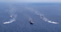 The forward-deployed amphibious assault ship, USS America (LHA 6), center, steams in formation with the amphibious dock landing ship USS Rushmore (LSD 47), second from left, the Japan Maritime Self-Defense Force (JMSDF) tank landing ship JS Kunisaki (LST-4003), second from right, and two JMSDF landing craft during Exercise Iron Fist in the Philippine Sea, Feb. 28.