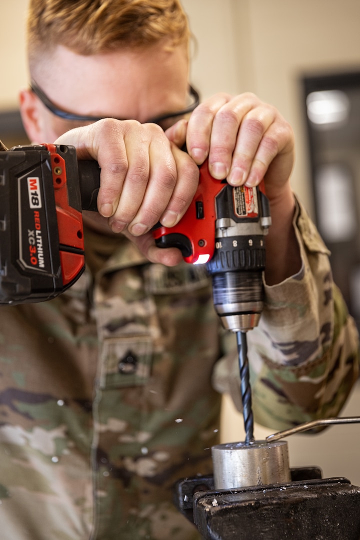 Oklahoma Army National Guard member Staff Sgt. Conley Rosdahl, a surface maintenance mechanic with a team from Field Maintenance Shop Nine, drills a pilot hole during the Mechanic of the Year competition held at the Combined Support Maintenance Shop in Norman, Oklahoma, Feb. 26, 2025. The Guardsmen came together for the fourth annual competition, teaming up to showcase their mechanic skills and connect with fellow competitors.(Oklahoma National Guard photo by Spc. Danielle Rayon)