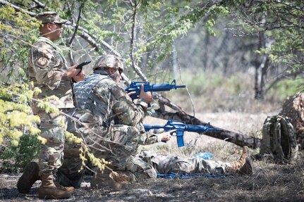 An exercise cadre monitors Airmen protecting an injured member during a field training exercise at Joint Base Pearl Harbor-Hickam, Hawaii, Feb. 2, 2025. The exercise tested the Airmen's tactical abilities and emphasized the importance of mental resilience and decision-making under pressure.