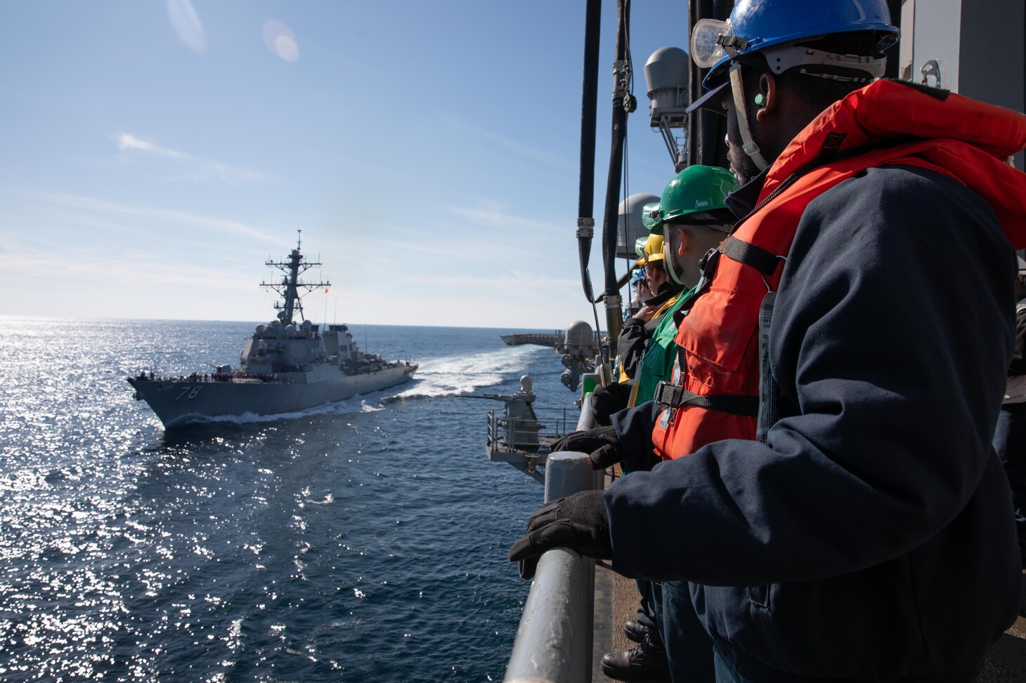 Sailors assigned to the Wasp-class amphibious assault ship USS Iwo Jima (LHD 7) watch as the Arleigh Burke-class destroyer USS Porter (DDG 78) pulls alongside Iwo Jima during a fueling-at-sea event.