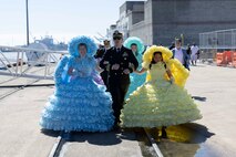 Trail Maids escort Cmdr. Bradley D. Steidle, commanding officer of USS McFaul (DDG 74), after mooring in Mobile, Alabama for Mardi Gras, Feb. 28, 2025.