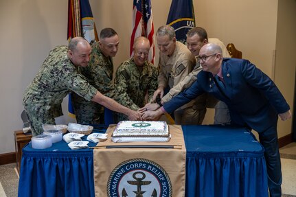 From left to right, Fleet Master Chief John Perryman, United States Fleet Forces Command, Brig. Gen. Thomas Armas, deputy commander, Marine Forces Command, Adm. Daryl Caudle, commander, USFFC, Capt. Eric Kellum, Chief of Staff, Naval Surfaces Forces Atlantic, Force Master Chief Jon Lonsdale, Naval Surface Forces Atlantic, and Mr. Rick O’Rawe, Director of the Norfolk Navy and Marine Corps Relief Society (NMCRS) perform a ceremonial cake cutting during the 2025 NMCRS Active-Duty Fund Drive kick-off event at USFFC, February 28, 2025.