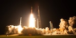 Shuttle begins launch from the ground at night.