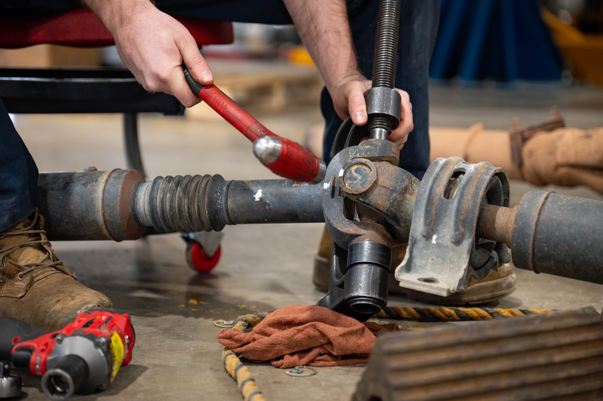 Mechanics perform maintenance on a vehicle.