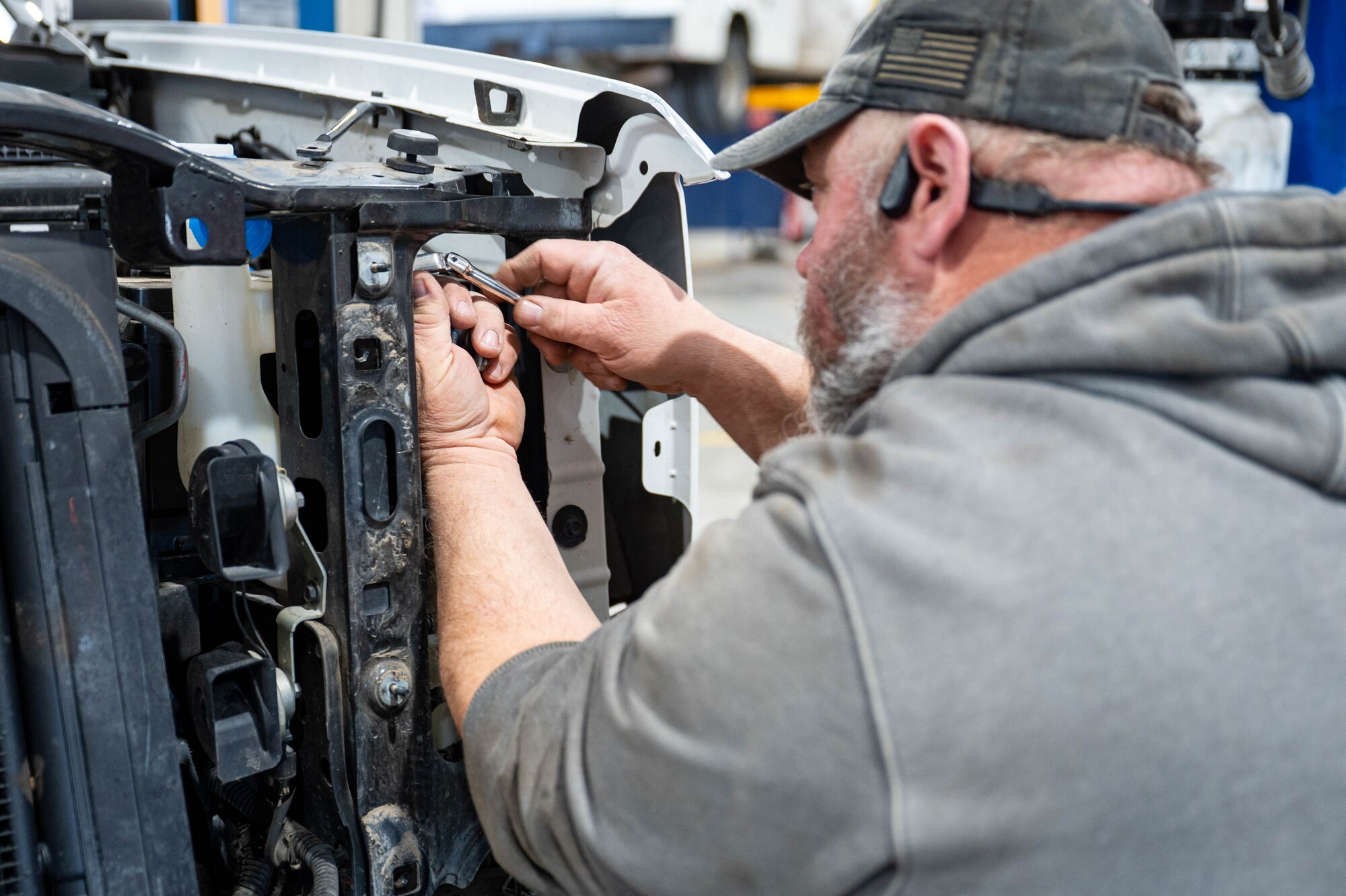 Mechanics perform maintenance on a vehicle.