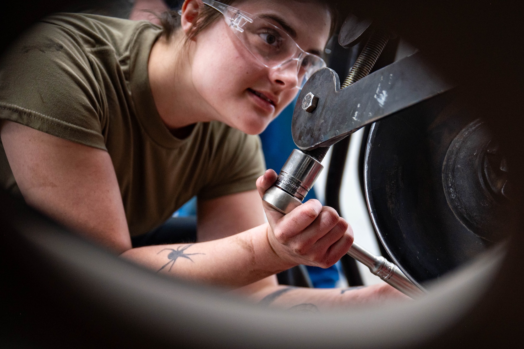 Mechanics perform maintenance on a vehicle.