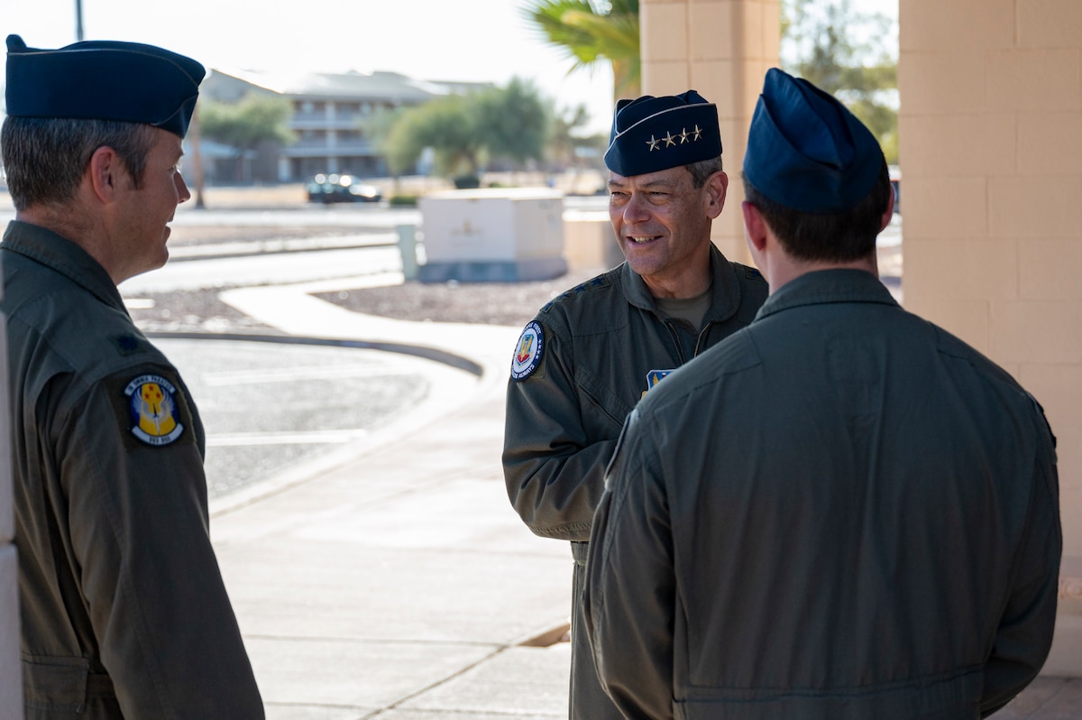 U.S. Air Force Gen. Ken Wilsbach, commander of Air Combat Command, center, speaks with Airmen after presenting one of them with his challenge coin at Davis-Monthan Air Force Base, Arizona, Feb. 27, 2025. During his time at DM, Wilsbach coined multiple Airmen from various squadrons who performed above and beyond their normal duties. (U.S. Air Force photo by Senior Airman Devlin Bishop)