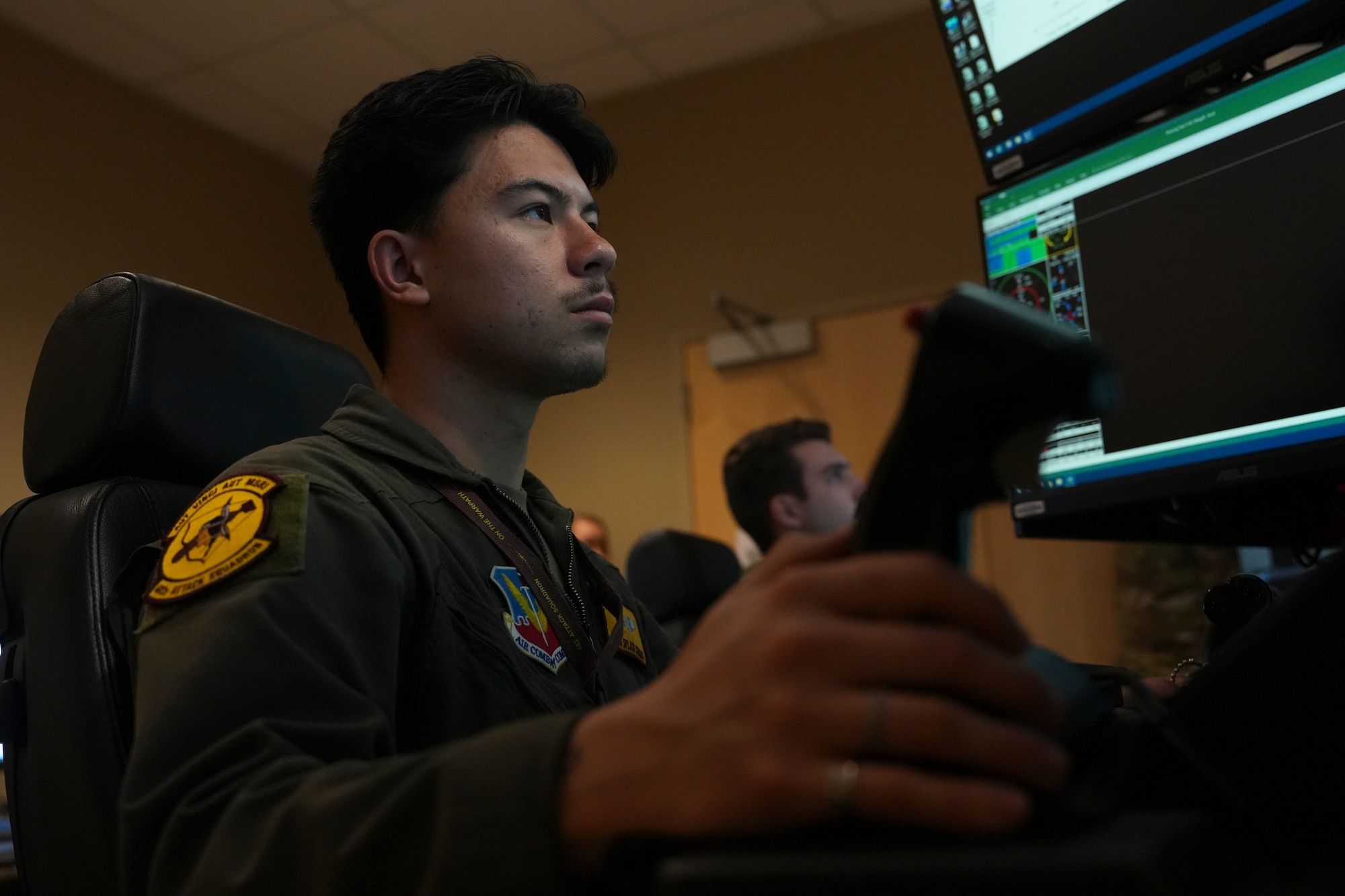 A man in a military uniform operates a flight simulator.
